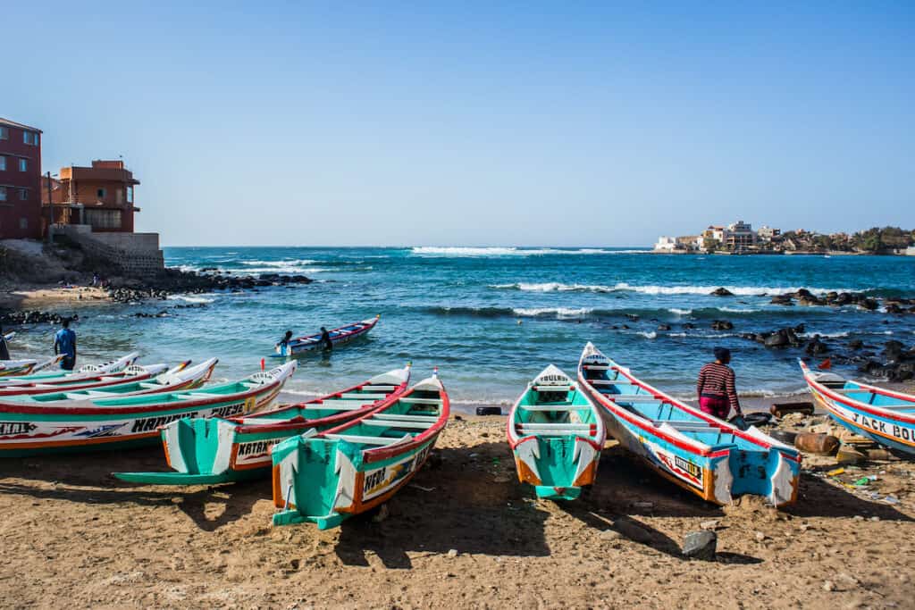 Colorful boats used by fishermen standing in the bay of Ngor on a sunny day.